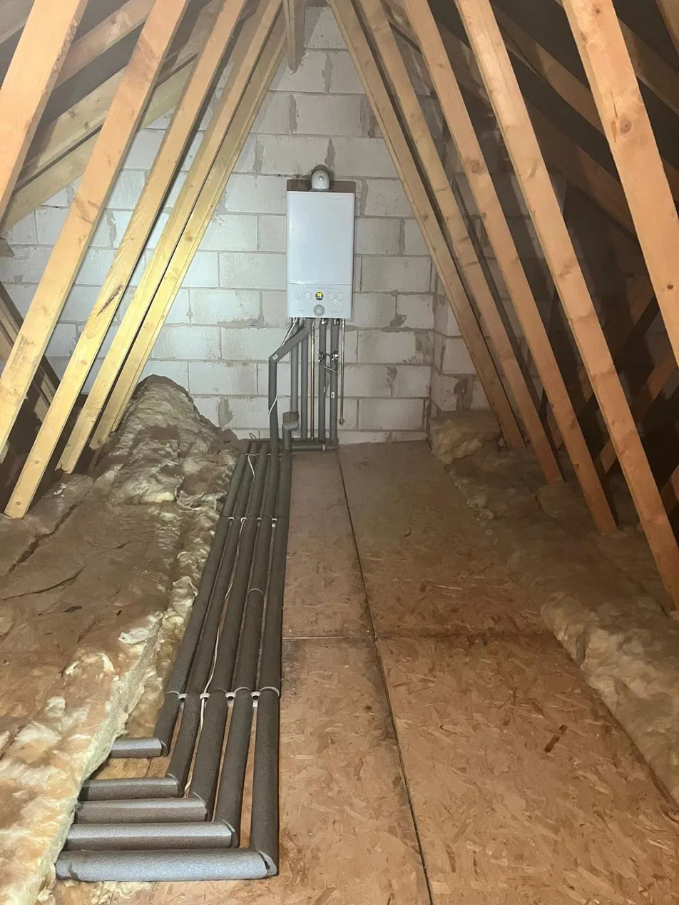 Recent gas boiler installation in a loft with neatly lagged pipework